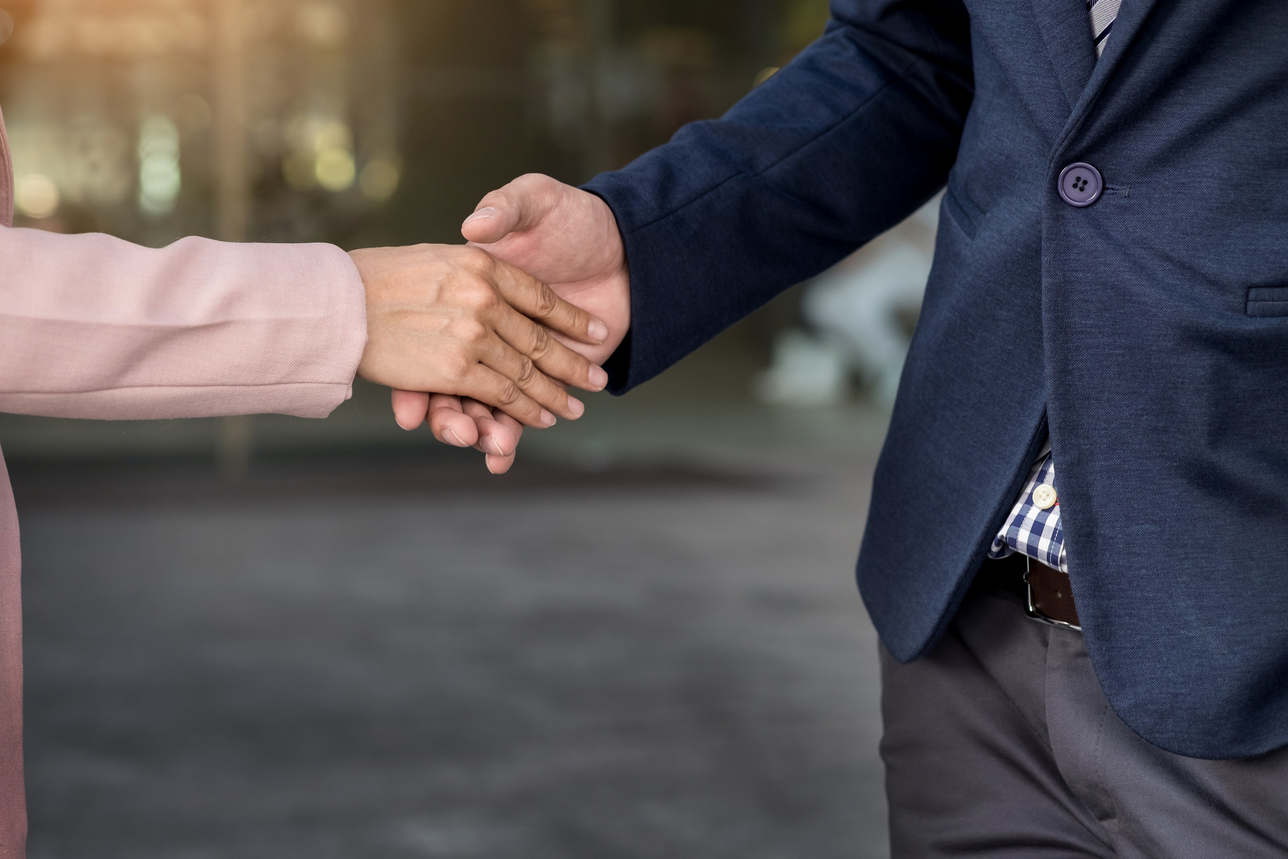 Professional handshake between two individuals in business attire, representing a successful job referral process and networking opportunity through Refered.